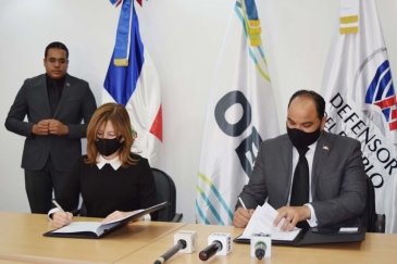 Catalina Andújar Scheker, representante residente de la OEI en la República Dominicana, y el Defensor del Puello Pablo Ulloa, firman el acuerdo entre ambas instituciones.